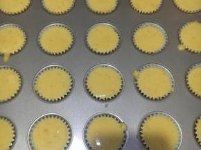 模具垫上同型号的纸杯，倒入蛋糕糊，正好20个，九分满，不多不少。