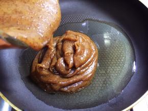 不粘平底锅中放入玉米油，倒入做熟的红枣糊