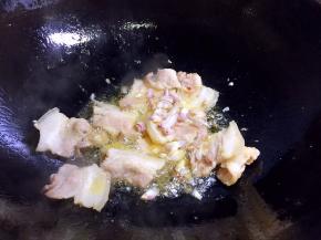 翻炒1-2分钟，使肥肉中的油脂炒出来一些，放入毛葱翻炒