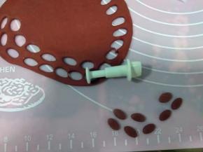 深色红面团擀成面片，用小椭圆模具压出小椭圆