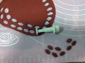 深色红面团擀成面片，用小椭圆模具压出小椭圆