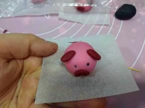 鼻子用牙签戳两个洞，用黑色面团揉两个小点，当眼睛