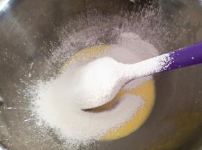 3.	筛入低筋面粉拌匀，低筋面粉过筛可以将面糊搅拌得更均匀，黄油融化后倒入其中一起搅拌均匀，