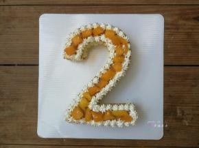 然后开始组装数字蛋糕，先放一片切好的数字蛋糕片，在外围挤满一圈奶油，中间摆放夹心的软质水果，我用的是芒果，然后再放上第2片数字蛋糕片，重复操作挤一圈淡奶油再放夹心水果