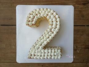 盖上第3片数字蛋糕片，在表面均匀地挤满小奶油花