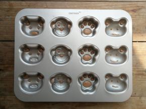 在模具内小动物的五官凹陷处填入可可面糊，立即送入提前预热好的烤箱160度烘烤1分钟