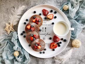 把草莓和蓝莓洗净，草莓切块，放在松饼上，然后撒上糖霜即可，再搭配牛奶，棒棒哒～