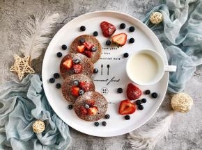 把草莓和蓝莓洗净，草莓切块，放在松饼上，然后撒上糖霜即可，再搭配牛奶，棒棒哒～