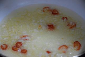 起锅热油，倒入小红椒和蒜碎炒香