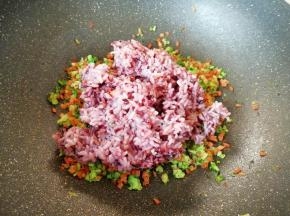 将杂粮饭倒入炒好的蔬菜里面。