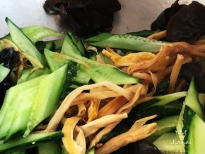 黄瓜提前切斜刀片，与木耳、黄花菜一同加入锅中翻炒片刻。