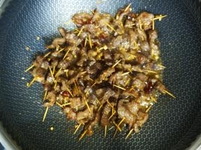 9.撒上孜然粉、花椒粉、椒盐炒均匀，撒上白芝麻，装盘
