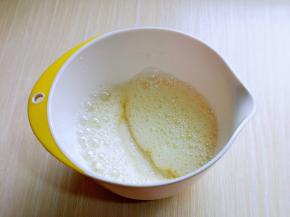 电动打蛋器将蛋白高速打发至呈现鱼眼泡。 加入三分之糖，继续高速打发。