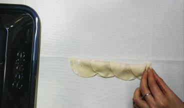 4.用手轻按着最边皮子，从一边慢慢往上卷起
