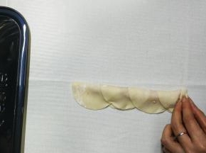 4.用手轻按着最边皮子，从一边慢慢往上卷起

