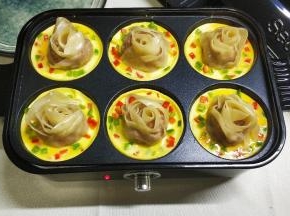 10.开盖，水烧干后倒入蛋液，蛋液快成型时，撒上青红椒碎做装饰。
