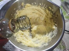 接着把1个蛋黄和1g香草精也加进去，继续用打蛋器最低那一档把蛋黄混匀进去，必须确保混匀了，期间用刮刀挂一下碗边，它和盐都是用来调味的，这样黄油曲奇味道才不会只有甜味那么单调，有一丝丝的咸和香草味。