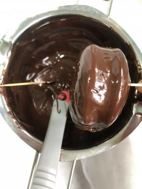 用牙签辅助把巧克力裹上蛋糕片。