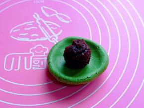 取一块面团用手指捏一个薄再放入豆沙馅。