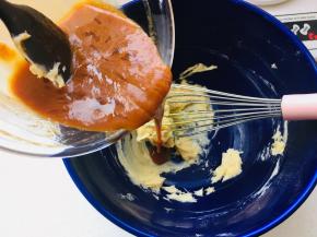 6、将混合好的焦糖鸡蛋液从冰箱取出，分次加入到黄油糊中，每添加一次都要充分的搅拌进去，再添加下一次。