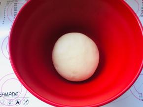 3、将面团放入到发酵盆中，轻轻压扁些，让发酵时的面团的温度尽可能的一致，表面覆盖保鲜膜进行基础发酵