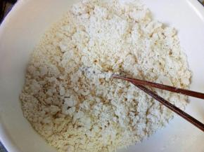 开水缓慢倒入面粉中，边用筷子搅拌成絮状