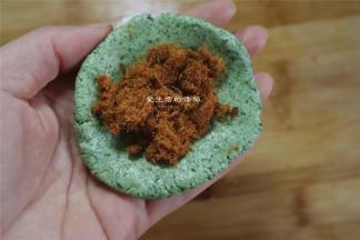 将面团分成40克一个的小剂子，手捏开，放入适量的蛋黄和肉松
