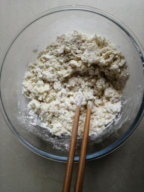 把酵母水倒入面粉里，用筷子拌成絮状