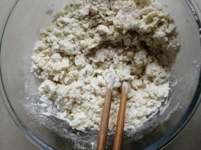 把酵母水倒入面粉里，用筷子拌成絮状
