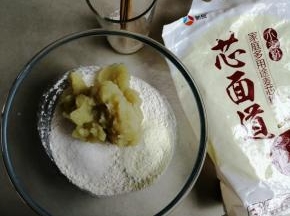 用8克温水溶解酵母，把面粉、奶粉、糖和打好的160克红薯泥都倒入和面盆里。