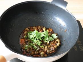 翻炒均匀后炖煮至汤汁快收干即可出锅，出锅前撒上香菜碎翻拌均匀即可；