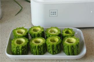 然后将苦瓜切短段，然后将籽去掉摆盘备用。