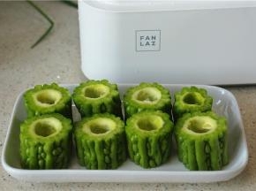 然后将苦瓜切短段，然后将籽去掉摆盘备用。