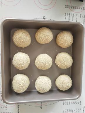 面包表面喷水，沾满白芝麻，放入学厨24*24厘米的烤盘中发酵到2倍大。
