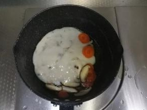 不粘锅里，开中火，倒入一点点玉米油，油温热，下香菇片胡萝卜片翻炒1-2分钟。倒入整包奶油培根意面酱。翻炒均匀。