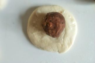 把面团略略按扁包入豆沙馅