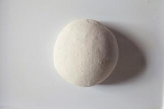 把面团放在案板揉搓排出空气。可撒适量干面粉防粘。