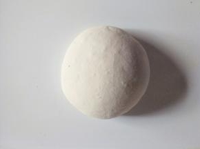 把面团放在案板揉搓排出空气。可撒适量干面粉防粘。