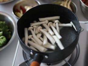 雪平锅内到适量水烧开加入少许盐、油，先焯白玉菇，菌类的潮水时间稍微长些，一定要焯熟。