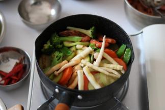 将所有之前焯、炒熟的菜、虾和火腿片全部倒进锅内，翻炒均匀