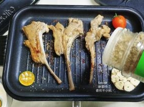 6.多功能锅转到2档，在羊小排上洒入杂锦香草
