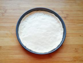 擀成和模具一般大小面饼，放进披萨盘里。