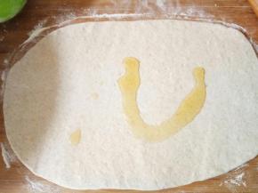 发酵好的面团充分揉压排气然后松弛十分钟，根据自己饼铛大小取一块小于饼铛面积三倍的面团擀成一个方形的大面片，倒油在面片上涂抹均匀