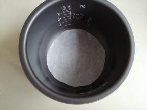 在电饭煲内胆铺一张裁剪好的油纸，方便脱模，不铺油纸的话，可以在底部抹上薄薄一层玉米油