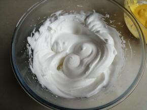 用电动打蛋器把蛋清打至粗泡（蛋清一定要装在无水无油的盆里），加入1/2糖，打发至有纹路的状态，再倒入剩余的糖，继续打发至提起打蛋头，呈直立小尖角的干性发泡的状态