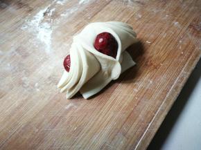 将最上面的一片面片两边轻轻向中间拉，将红枣包裹捏紧