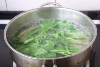 将菠菜放在开水里焯烫一下。
菠菜中含有蛋白质、氨基酸，能够促进胚胎大脑发育及智力发育。
菠菜中含有钙、磷等矿物质，有利于胎儿骨骼及牙齿的发育。菠菜中含有叶酸，能促进造血，预防胎儿神经管畸形，有利于胚胎的健康发育。
菠菜中含有粗纤维，增强胃肠蠕动，促进大便排出，预防便秘，有利于孕妇及胎儿的身体健康。但需适量食用，而对于脾虚便溏的孕妇应禁止食用。