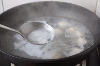 将鸡肉丸子养至变色后开火，撇去浮末。