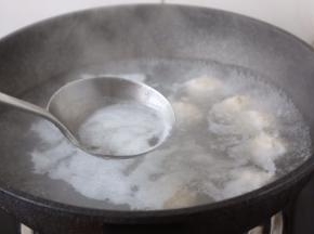 将鸡肉丸子养至变色后开火，撇去浮末。
