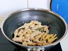 加入焯水的鸡爪煸炒至微黄。